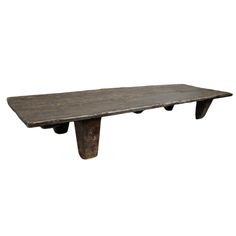 an old wooden table with two legs and a long slab on the top, against a white background