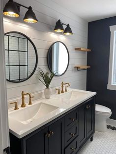 a bathroom with two sinks and three mirrors on the wall next to eachother