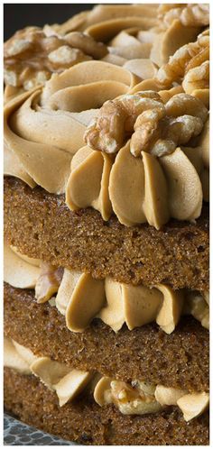 a close up of a cake with nuts on top and frosting in the middle