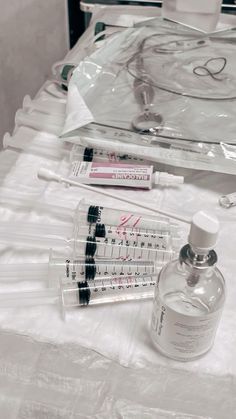 an assortment of medical supplies sitting on a white tablecloth covered table with clear plastic bags