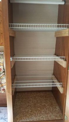 an empty closet with shelves and carpeted flooring