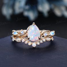 an opal and diamond ring on top of a table