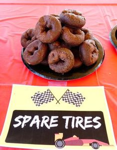 there are donuts that are on the plate and in front of the sign for spare tires