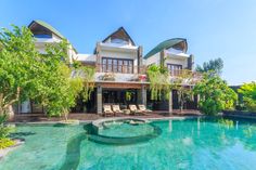 an outdoor swimming pool next to a large house