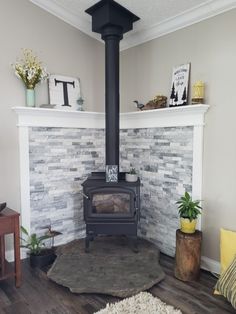 a living room with a wood stove and white brick wall in the corner, surrounded by potted plants