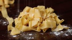 pasta being sprinkled with flour on a wooden table