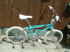 a blue bicycle parked next to a wooden fence