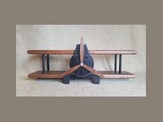 a wooden bench sitting on top of a white floor next to a shelf with two benches