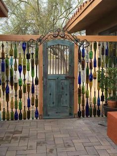 a wooden gate with glass bottles hanging on it's sides and an open door