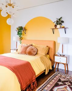 a bedroom with yellow walls and orange bedding