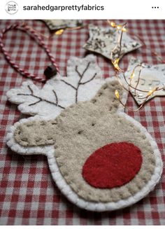 a christmas ornament is hanging on a red and white checkered tablecloth