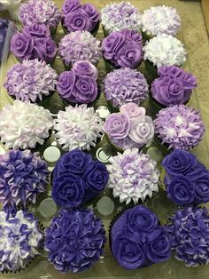 cupcakes with purple and white frosting are arranged on a table