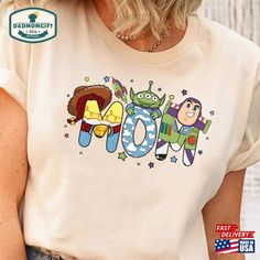 a woman wearing a t - shirt with the word mom printed on it in cartoon characters