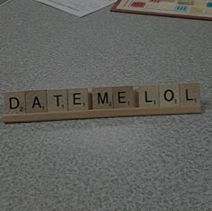 scrabble tiles spelling the word date me lol on top of a table