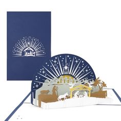 the nativity scene pop - up card is shown in blue and white, with an envelope