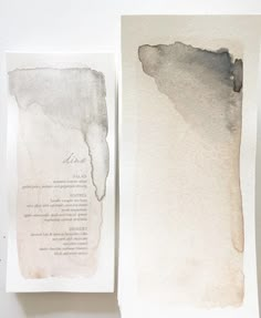 two pieces of paper with watercolor paint on them, one is white and the other is gray