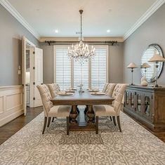 a formal dining room with chandelier and large rug