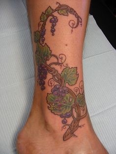 a foot with a vine and leaves tattoo on it