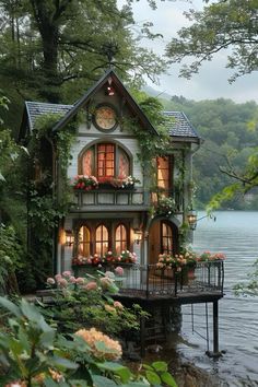 a house that is sitting on top of a body of water with flowers growing out of the windows