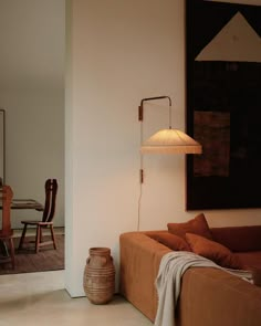 a living room filled with furniture and a lamp next to a painting on the wall