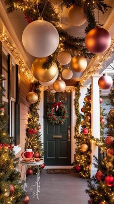 christmas decorations are hanging from the ceiling and on the outside of a house with green door