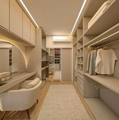 a large walk in closet with lots of shelves and drawers on the wall, along with a white chair