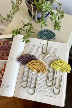 an open book sitting on top of a table with paper clips in front of it