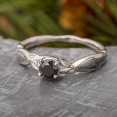 a silver ring with a black diamond on it