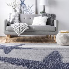 a living room with a gray couch and blue rug