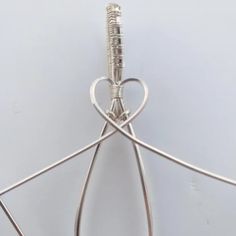 a pair of scissors is attached to a wire with a heart shaped hook on it