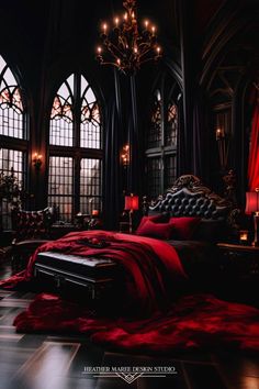 a large bed in a very dark room with chandelier and red blankets on it