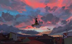 a bird flying in the sky over some houses and buildings at sunset or dawn with pink clouds