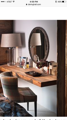 a bedroom with a mirror, desk and chair next to a lamp on the wall