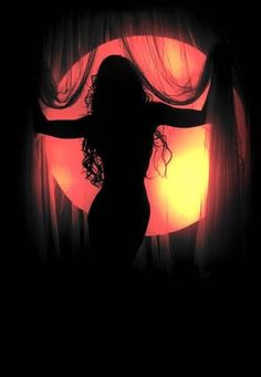 the silhouette of a woman standing in front of a curtain