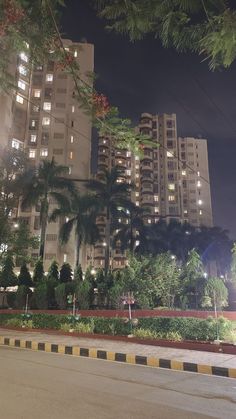 an empty street in front of tall buildings at night