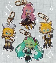 four keychains with anime characters on them sitting on a piece of paper next to each other