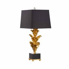 a table lamp with a black shade and gold leaf design on the base, against a white background