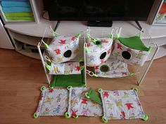 four baby cribs sitting on the floor in front of a tv