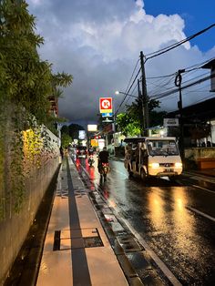 people are walking down the street in the rain