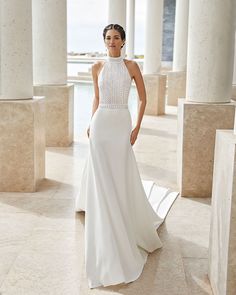 a woman in a white wedding dress posing for the camera with her hands on her hips