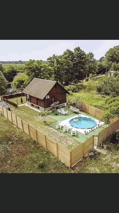 an aerial view of a house with a pool in the yard and a fence surrounding it