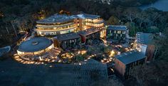 an aerial view of a large building with many lights on it's sides at night