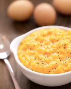 a white bowl filled with food next to eggs