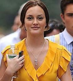 a woman in a yellow dress holding a drink