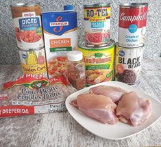 the ingredients for this dish are displayed on a white plate, along with cans of canned food