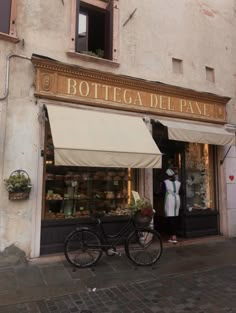 a bicycle is parked in front of a store with an awning over the door