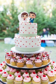 a wedding cake and cupcakes on a table