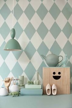 a blue and white checkered wallpaper with wooden blocks on the shelf, shoes and vases next to it