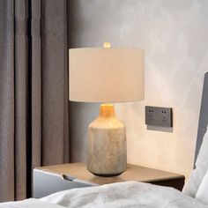 a lamp on a nightstand next to a bed