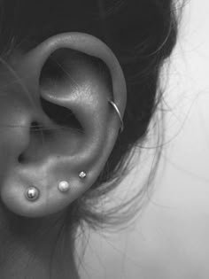 a woman's ear with two piercings on it